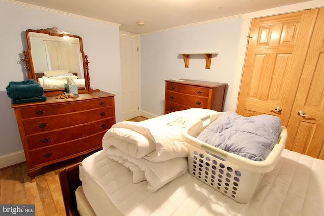 bedroom featuring wood-type flooring and ornamental molding