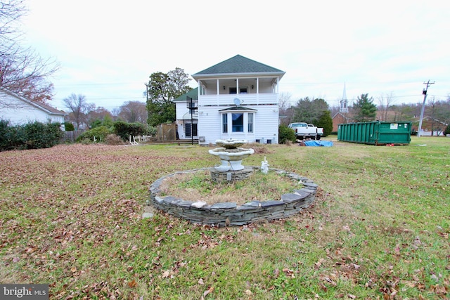 back of house featuring a yard and a balcony