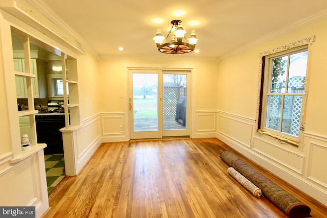 doorway to outside featuring crown molding, light hardwood / wood-style flooring, and a chandelier