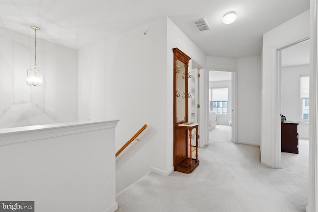 hallway featuring light colored carpet