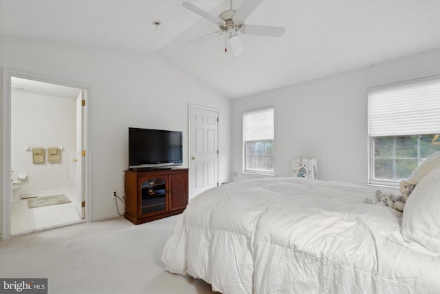 carpeted bedroom with connected bathroom, ceiling fan, and vaulted ceiling