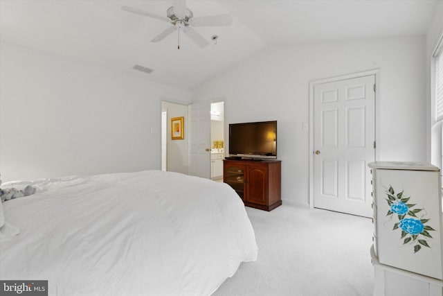 bedroom with light carpet, connected bathroom, vaulted ceiling, and ceiling fan