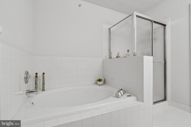 bathroom featuring a relaxing tiled tub and tile patterned floors