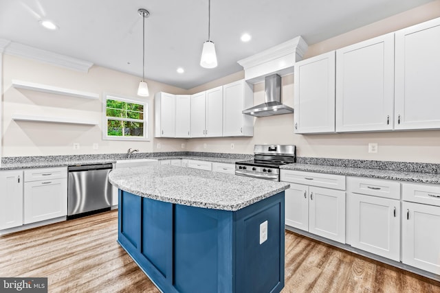 kitchen with white cabinetry, wall chimney range hood, and appliances with stainless steel finishes