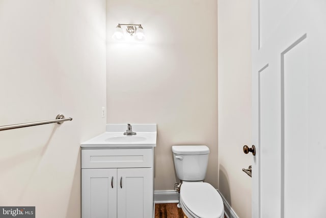 bathroom with vanity, toilet, and wood-type flooring