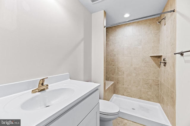 bathroom featuring tiled shower, tile patterned floors, vanity, and toilet