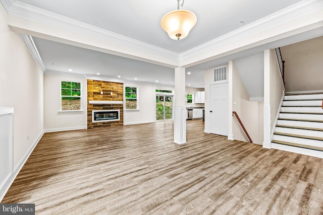 unfurnished living room featuring a fireplace, light wood-type flooring, and crown molding