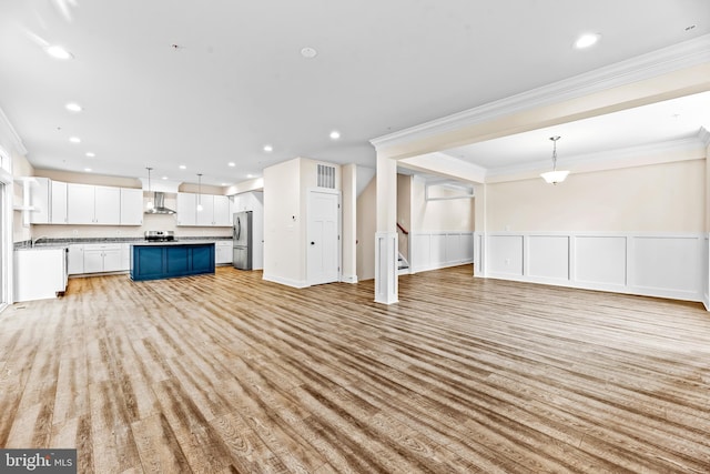 unfurnished living room with crown molding and light hardwood / wood-style floors