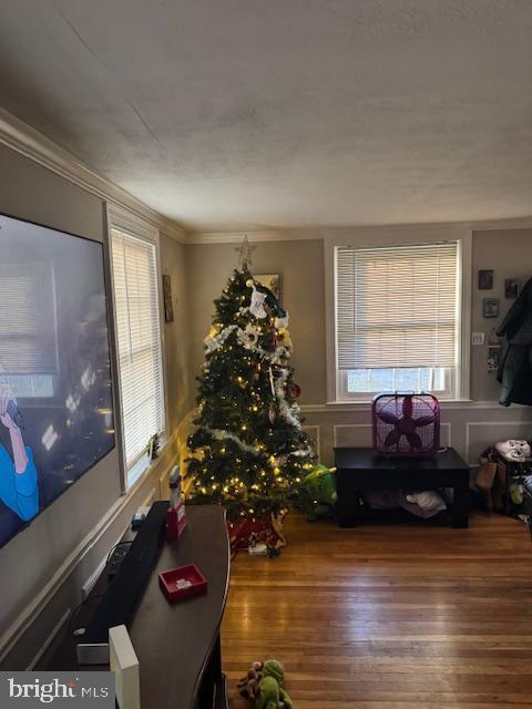 living room featuring wood-type flooring and crown molding