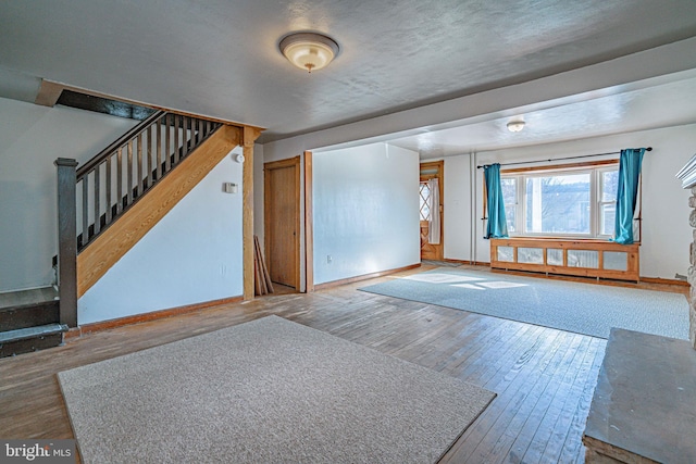 interior space with a textured ceiling and hardwood / wood-style flooring