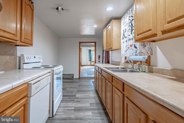 kitchen with dark hardwood / wood-style flooring, backsplash, white appliances, sink, and tile counters