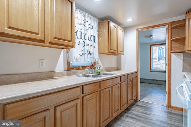 kitchen with light brown cabinetry, white range, a baseboard heating unit, sink, and hardwood / wood-style floors