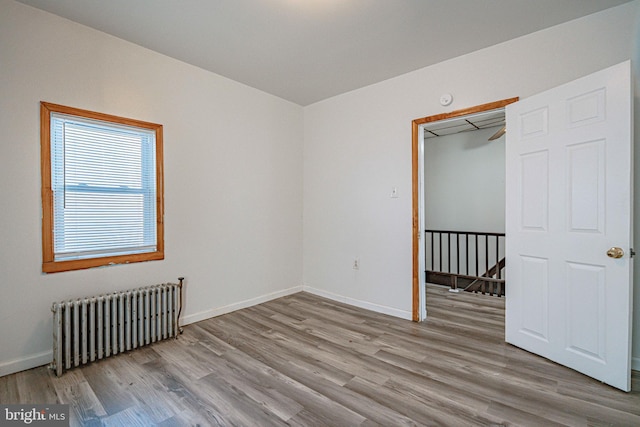 unfurnished bedroom featuring light hardwood / wood-style floors and radiator