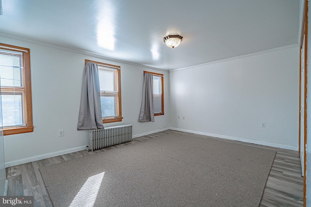 spare room featuring light hardwood / wood-style floors, radiator, and ornamental molding