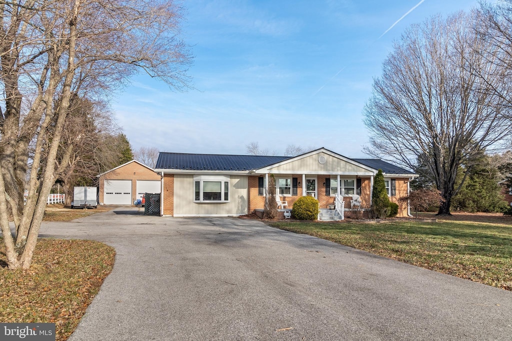 ranch-style home with an outdoor structure, a front yard, a porch, and a garage