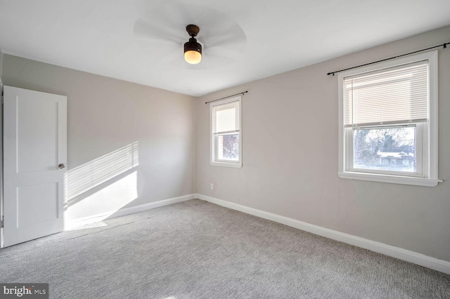 carpeted spare room with ceiling fan