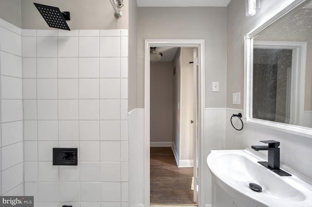 bathroom with a shower, sink, and wood-type flooring