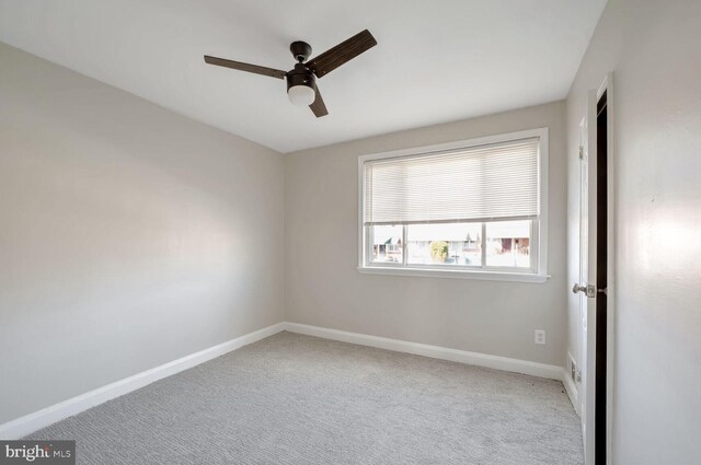 carpeted empty room featuring ceiling fan