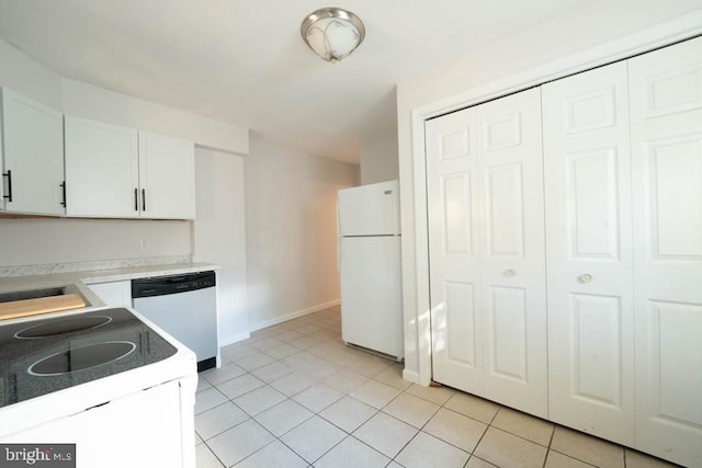 kitchen with sink, white cabinets, light tile patterned flooring, and white appliances