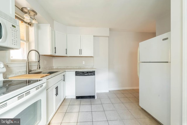 kitchen featuring sink, white cabinets, white appliances, and light tile patterned floors