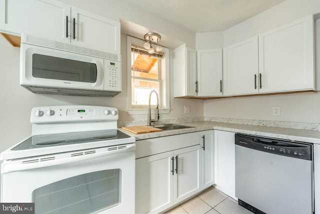 kitchen featuring white cabinets, light tile patterned floors, white appliances, and sink