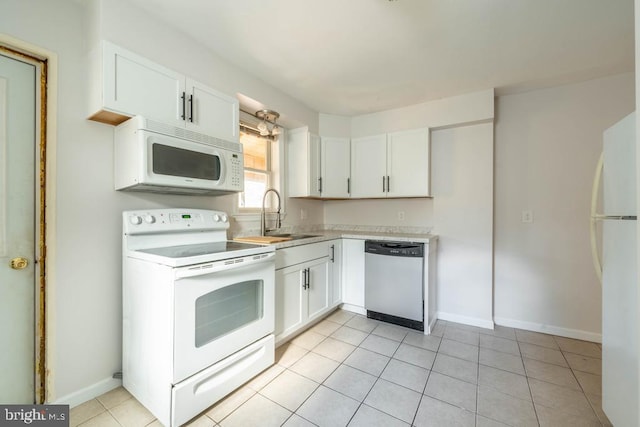 kitchen with light tile patterned floors, white appliances, white cabinetry, and sink