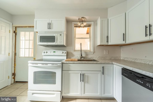 kitchen featuring white cabinets, white appliances, sink, and light tile patterned floors