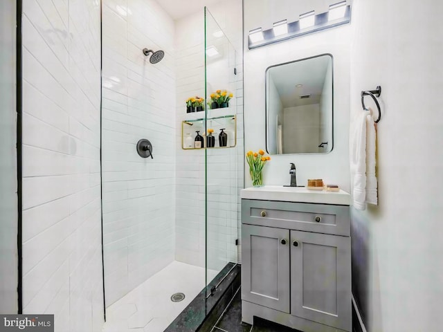 bathroom featuring a tile shower and vanity