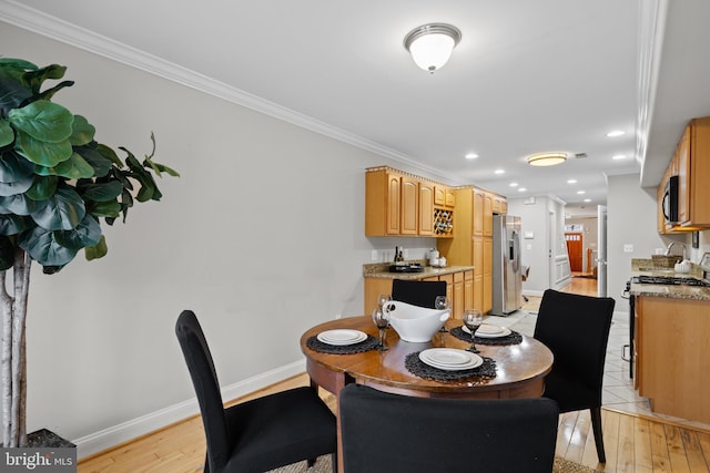 dining area with light hardwood / wood-style flooring and ornamental molding