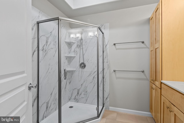 bathroom with tile patterned floors, vanity, and walk in shower