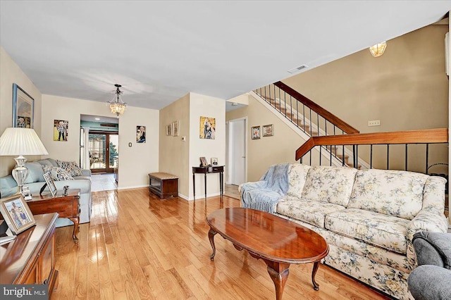 living room with light wood-type flooring and a chandelier