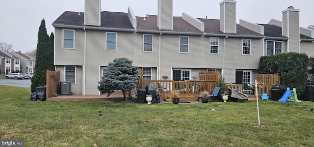 rear view of house featuring a lawn, a wooden deck, and central AC unit