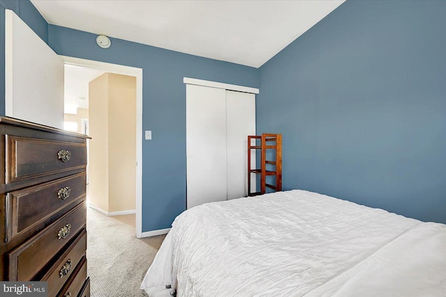 bedroom featuring light carpet and a closet