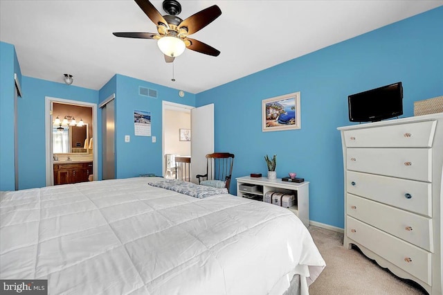 bedroom featuring ceiling fan, light carpet, and ensuite bath