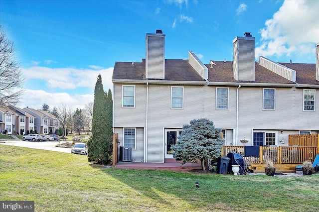 back of house with a lawn, central AC unit, and a deck