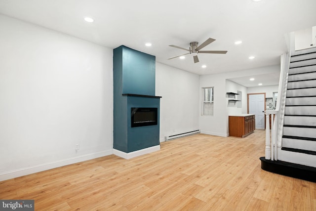 unfurnished living room with a fireplace, a baseboard radiator, light hardwood / wood-style flooring, and ceiling fan