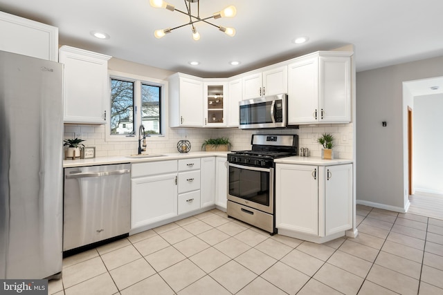 kitchen featuring light tile patterned floors, white cabinetry, sink, and appliances with stainless steel finishes