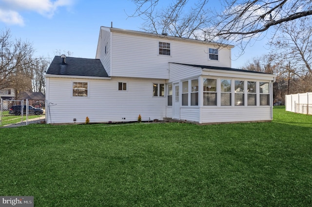 back of property with a yard and a sunroom