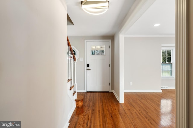 foyer entrance featuring crown molding and hardwood / wood-style flooring