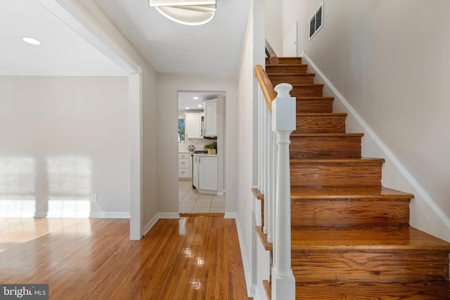 stairway with hardwood / wood-style floors