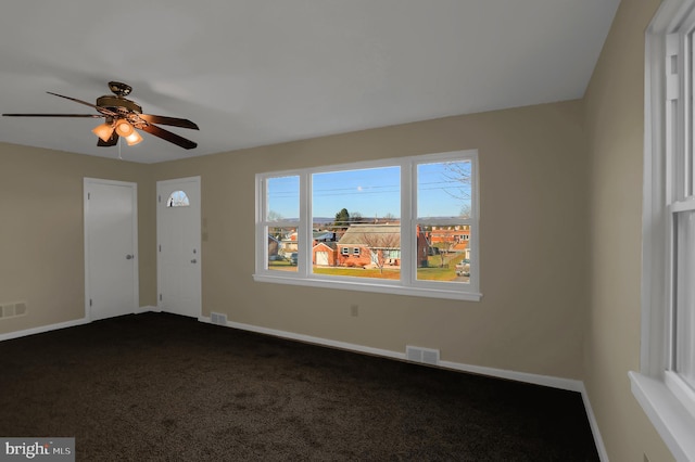 interior space with ceiling fan and dark carpet