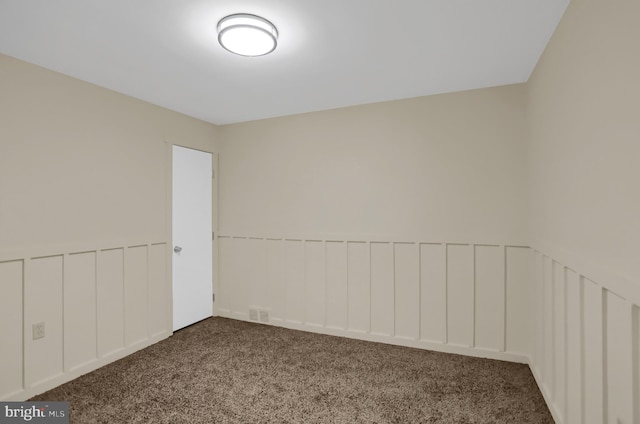 unfurnished room with dark colored carpet