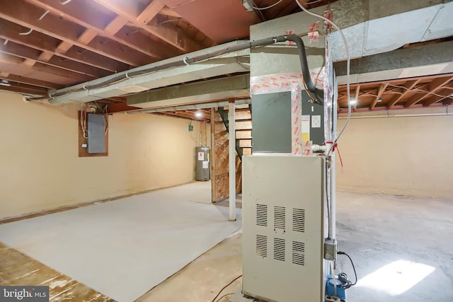 basement featuring electric panel, electric water heater, and heating unit