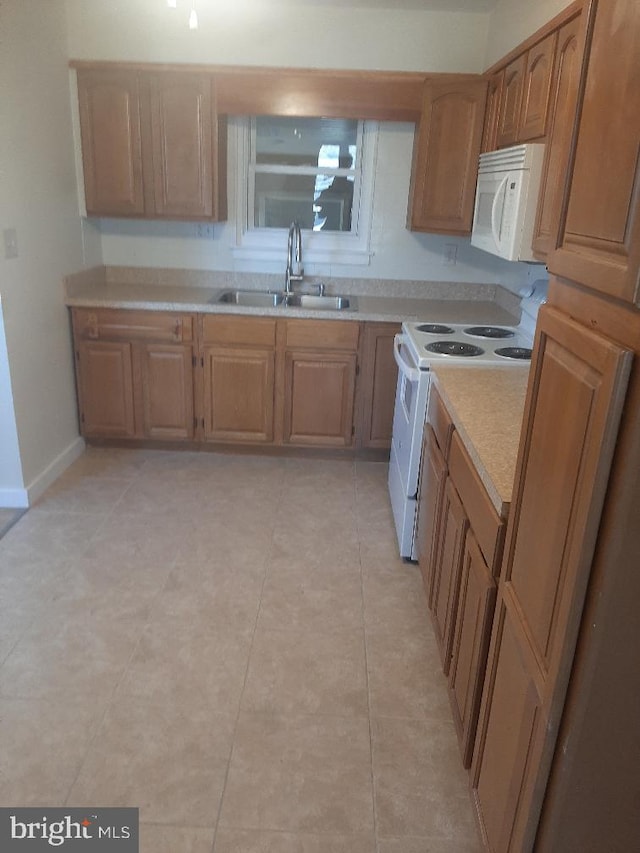 kitchen with white appliances, sink, and light tile patterned floors