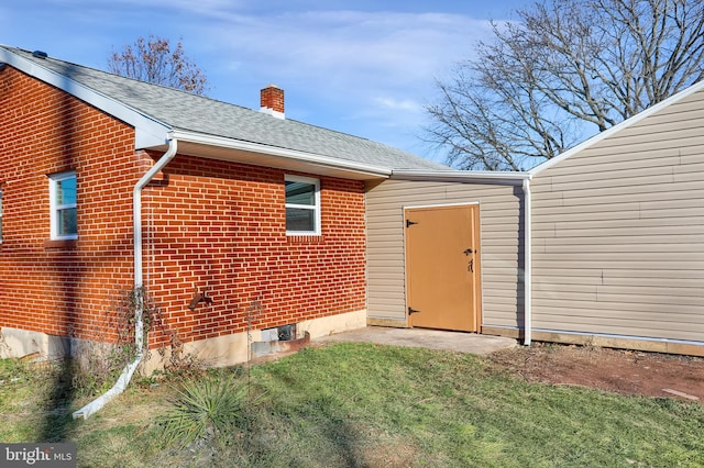 view of exterior entry featuring a yard