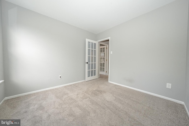 spare room with light carpet and french doors