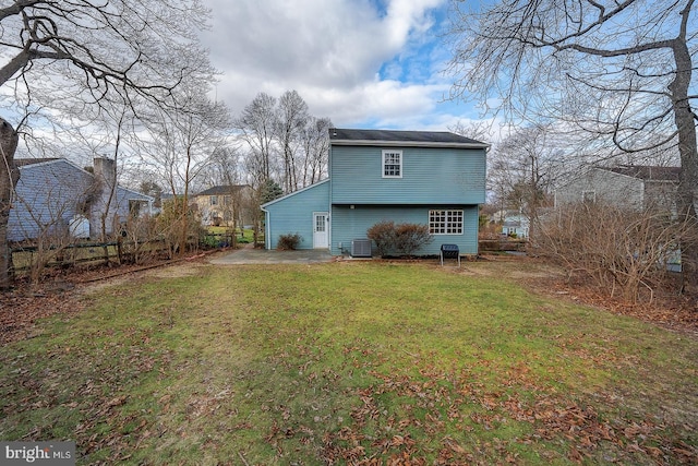 back of property featuring a lawn and central air condition unit