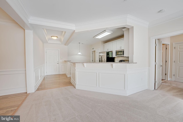 kitchen with white cabinetry, appliances with stainless steel finishes, crown molding, and hanging light fixtures