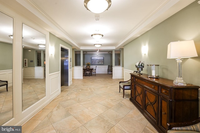 hall with a raised ceiling and crown molding