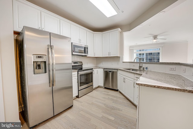 kitchen featuring sink, light hardwood / wood-style floors, white cabinetry, and appliances with stainless steel finishes